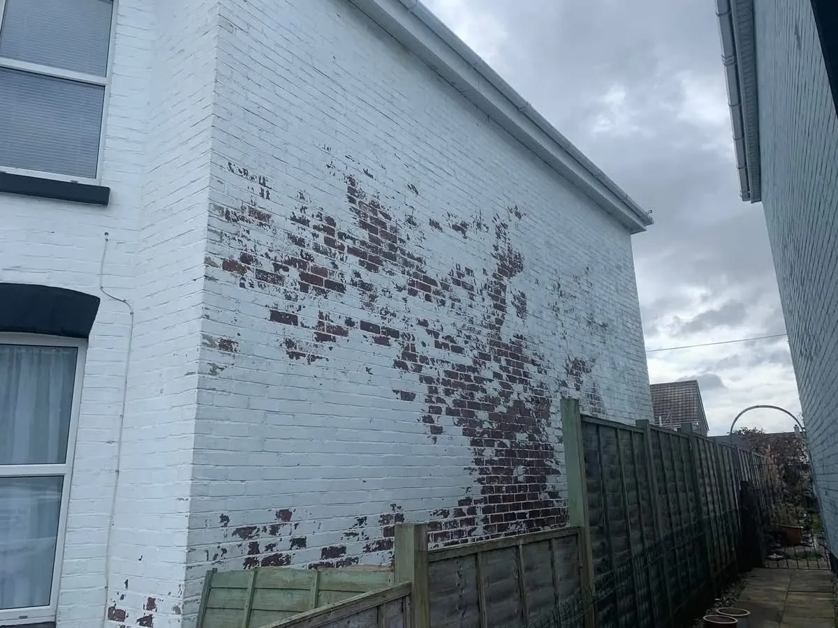 Peeling paint on a brick wall before redecoration in Okehampton