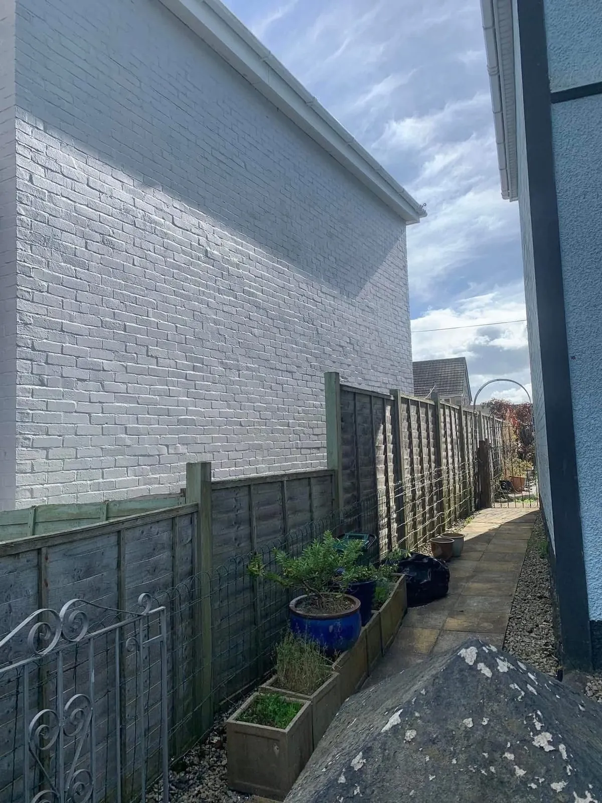 Freshly painted brick wall after preparation and masonry paint in Okehampton